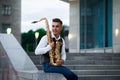 Male saxophonist poses at the stairs on street Royalty Free Stock Photo
