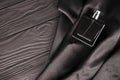 Male scent perfume bottle on dark silk background