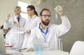 Male scientist or chemist carefully and thoughtfully examines the liquid in a test tube.