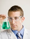 Male scientist examines beaker