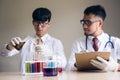 Two Scientist men test liquid substrance in lab