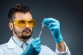 Male scientist, laboratory assistant in a white coat and glasses holds a bottle with a vaccine in his hands, medical tests, Royalty Free Stock Photo