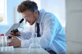 Male scientist using modern microscope in laboratory Royalty Free Stock Photo