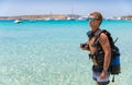 Male scuba diver standing on a beach