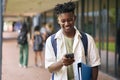 Male Secondary Or High School Student Outdoors At School Going To Class Looking At Mobile Phone Royalty Free Stock Photo
