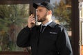 Male security guard with portable radio transmitter outdoors Royalty Free Stock Photo