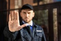 Male security guard showing Stop gesture outdoors