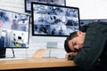 Male security guard sleeping near monitors at workplace Royalty Free Stock Photo