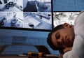 Male security guard sleeping near monitors at workplace Royalty Free Stock Photo