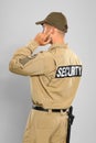 Male security guard in uniform radio earpiece on grey background