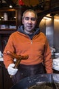 Male seller chef with german sausage on kitchen