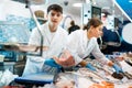 Male seller demonstrates large piece of tuna fillet at fish market Royalty Free Stock Photo