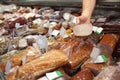 Male seller holding piece of deli meat in butcher shop