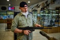 Male seller holds automatic rifle in gun store