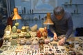 Male seller placing piece of jewelry on the counter preparing his stall for opening Royalty Free Stock Photo