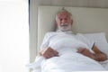 Male senior patient lying in hospital bed. Elderly man feeling sick need to rest in bed at home, ill man feeling pain need to Royalty Free Stock Photo