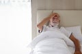 Male senior patient lying in hospital bed. Elderly man feeling sick need to rest in bed at home, ill upset man has a headache, Royalty Free Stock Photo