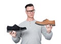 A male shoe seller with glasses holds two different shoes in his hands, showing them to the camera, offering a choice Royalty Free Stock Photo