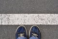 Male shoes on the asphalt road with white line, step into