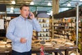 Male with shop list is calling wife for ask about products