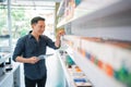 male shopkeeper checking the liquid stock at the shelf