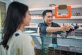 male shopkeeper helping the female customer to paying the vape stuff