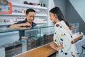 male shopkeeper pointing on the vape mods inside the display table