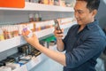 male shopkeeper taking photo of the liquid variant