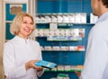 Male shopper with mature woman pharmacist