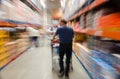 Male shopper in store with shopping cart