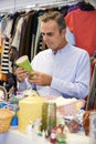 Male Shopper In Thrift Store Looking At Ornaments Royalty Free Stock Photo