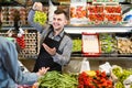 male shopping assistant helping customer to buy fruit and vegetables in grocery shop Royalty Free Stock Photo