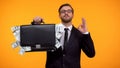 Male showing briefcase with money and doing ok gesture, payday lending service