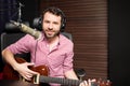 Male singer broadcasting a song live at radio station