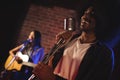 Male singer with female guitarist performing in nightclub Royalty Free Stock Photo