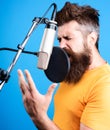 Male singer singing in condenser microphone. Professional vocalist in studio. Music, leisure concept. Royalty Free Stock Photo