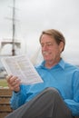 Male sitting on a bench with court papers in his hadn