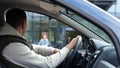 Male sitting in car waiting for daughter looking in window. Rear of male sit in vehicle waits for his kid from school Royalty Free Stock Photo