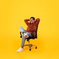 Male Sitting In Chair Holding Hands Behind Head, Yellow Background Royalty Free Stock Photo