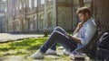 Male sitting under tree, using mobile phone, reacting to newsfeed, confusion