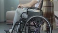 Male sitting wheelchair and touching his knees, inconsolable medical conclusion