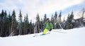 Male skier backpacker extremal freeriding skiing on ski desert wooded slope. Carving turn technique on snowy mountain.