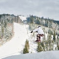 Male skier making jump while skiing in mountains. Royalty Free Stock Photo