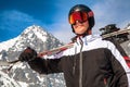 Male skier with ski goggles, helmet and skis posing in front of Lomnicky peak in High Tatras mountains Royalty Free Stock Photo