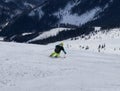 Male skier skiing downhill. Boy descending down on skis. Carve position. Atletic figure. Yellow helmet. Black backpack. Dangerous