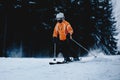 Male skier on a slope in the mountains. Frozen dark forest in the b