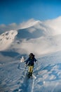 Male skier walking on deep white powdery snow path of snow-capped mountain Shpytsy in Ukraine