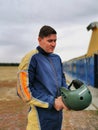 A male skydiver is preparing to jump. A young guy in a jumpsuit smiles and looks at the camera.