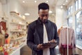 Male Small Business Owner Checks Stock In Shop Using Digital Tablet