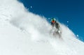 Male snowboarder curved and brakes spraying loose deep snow on